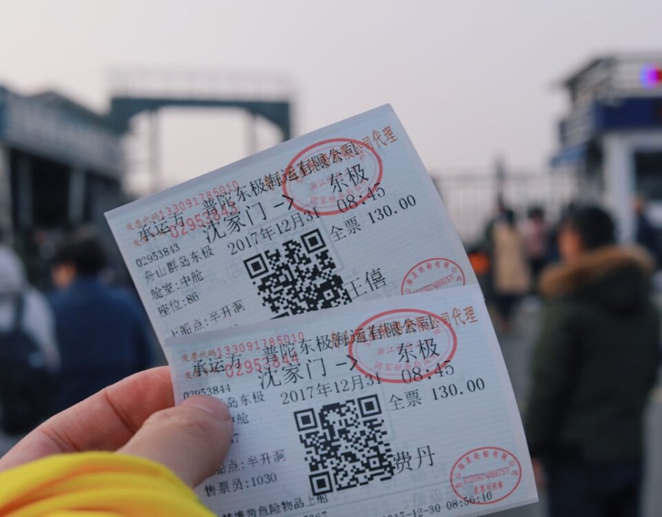 person holding two white tickets