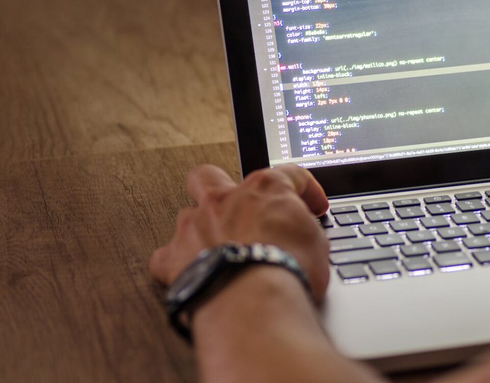 Qual linguagem de programação usar para sites corporativos? Person Wearing Black Watch Holding Macbook Pro