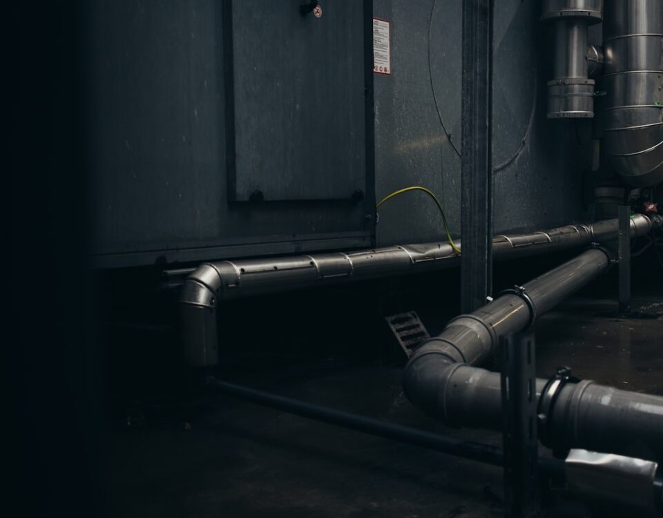 gray pipes mounted on concrete wall arrangement