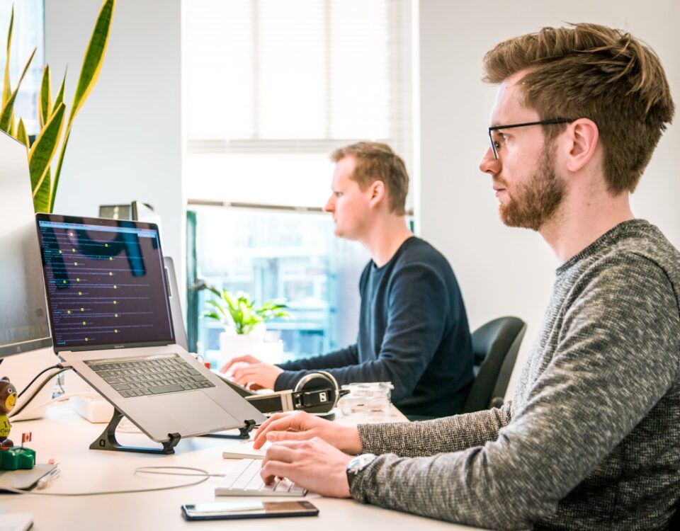 APIs para Gerenciamento de Contratos de Locação e Garantias man sitting on chair wearing gray crew-neck long-sleeved shirt using Apple Magic Keyboard