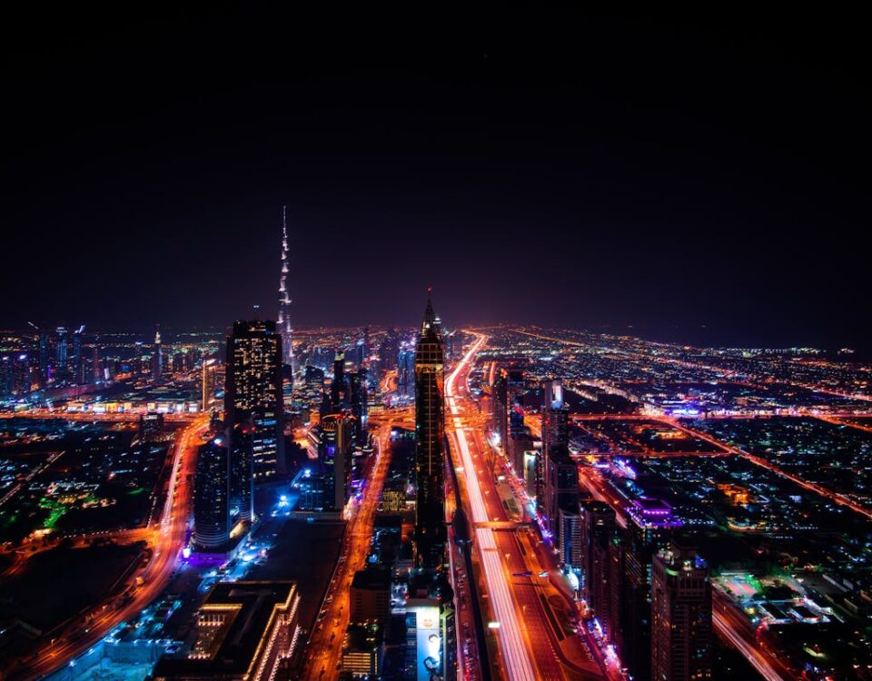 IA no planejamento urbano: como funciona? A breathtaking aerial view of Dubai's cityscape at night, highlighting the illuminated Burj Khalifa and surrounding skyscrapers.