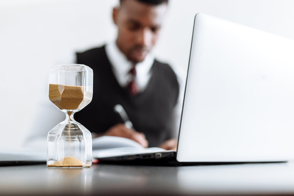 IA na defesa criminal: O futuro dos advogados criminalistas Businessman at desk with hourglass indicating time management and daily work routine.