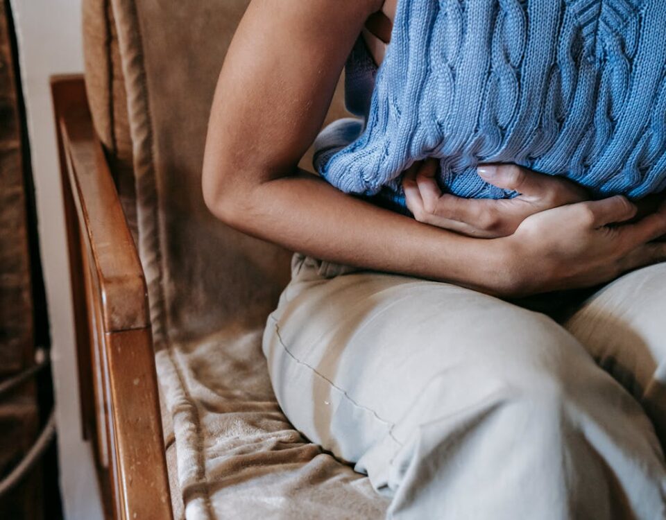 IA no diagnóstico precoce de doenças inflamatórias intestinais Crop unrecognizable female touching belly while having acute pain in stomach sitting on couch