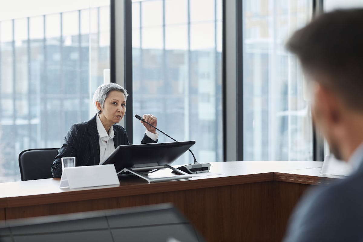 IA na análise de discursos políticos: como funciona? Businesswoman speaking at a corporate meeting in a modern office setting.
