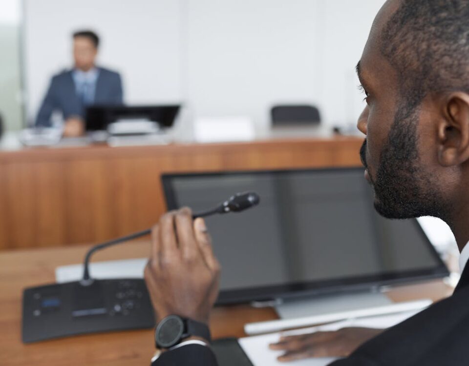 IA na análise de discursos políticos: como funciona? Bearded businessman speaks into microphone during office conference.