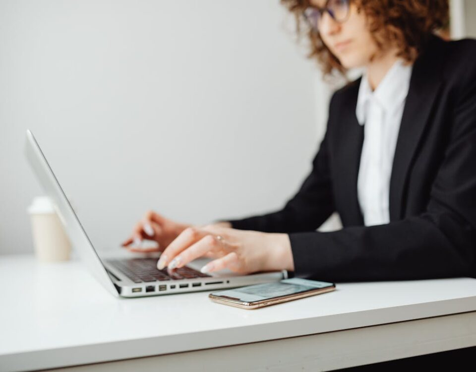 IA identifica advogados especialistas em planos de saúde Focused businesswoman working on a laptop at a desk in a modern office.