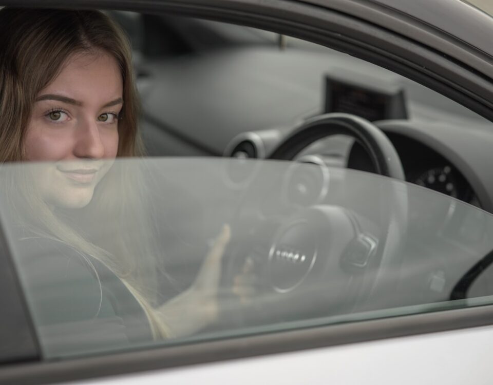 Como a IA está mudando o ensino de direção no Brasil a woman sitting in a car holding a steering wheel