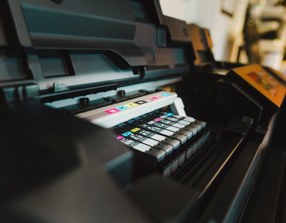 Impressoras inteligentes para criar rótulos adesivos com IA Detailed view of ink cartridges inside a digital inkjet printer in an office setting.