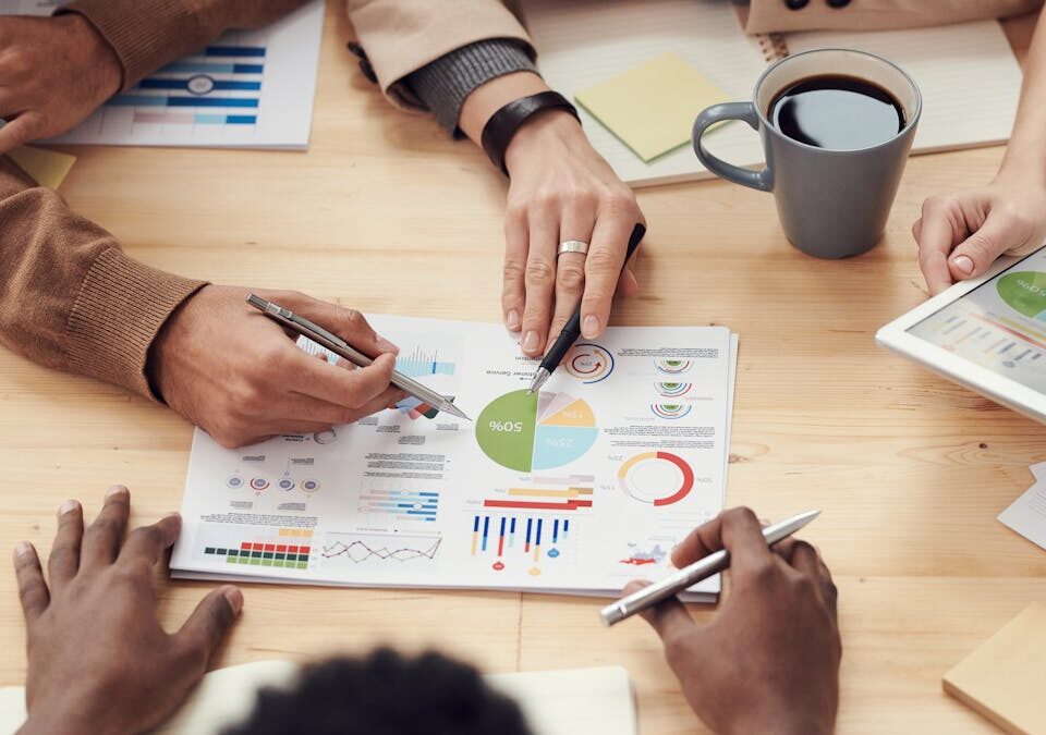 Por que dados são aliados de agências criativas modernas Colleagues discussing data and strategy in an office meeting.