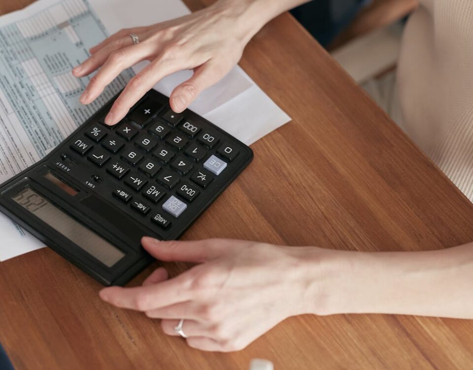 IA na formação de motoristas: O futuro da CNH Close-up of a woman using a calculator and reviewing bills at home.