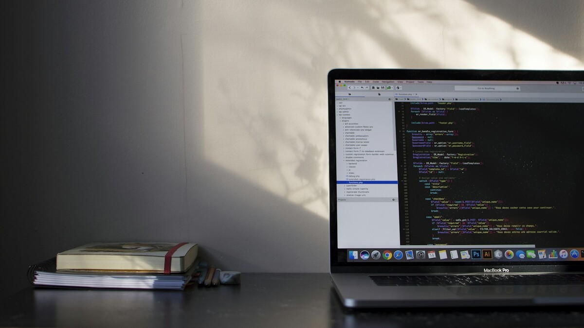 Como calcular em Python as horas semanais de uma escala 6x1? Notebook com código aberto sobre uma mesa, ao lado de livros