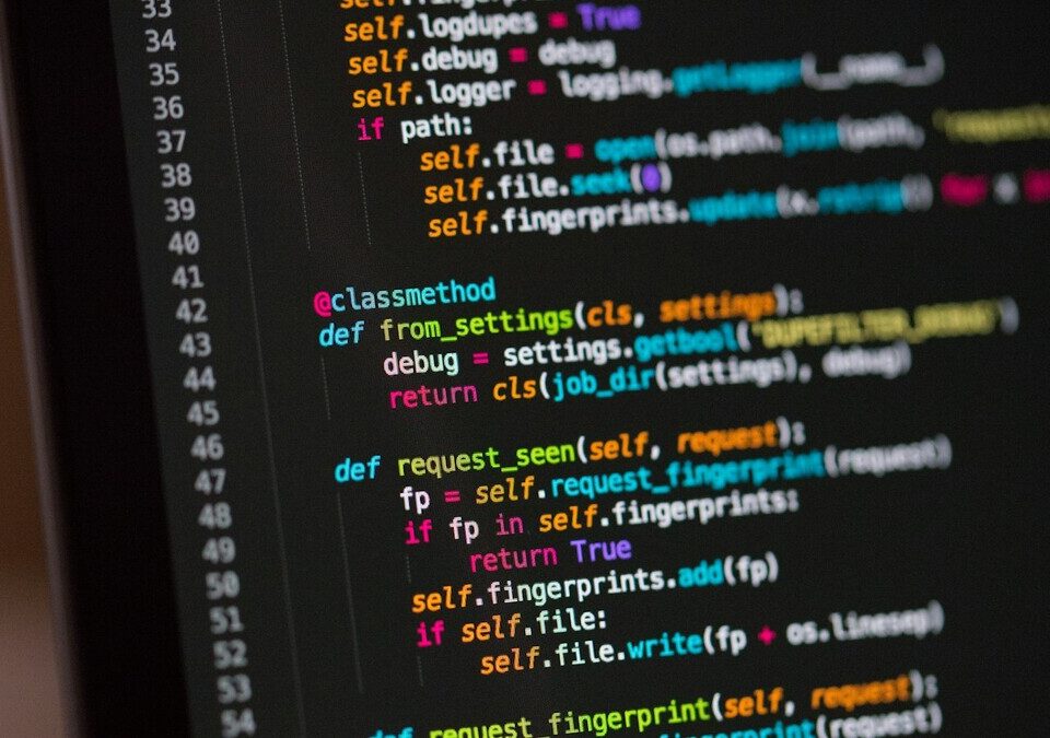 Tela de computador com linhas de código coloridas em editor escuro