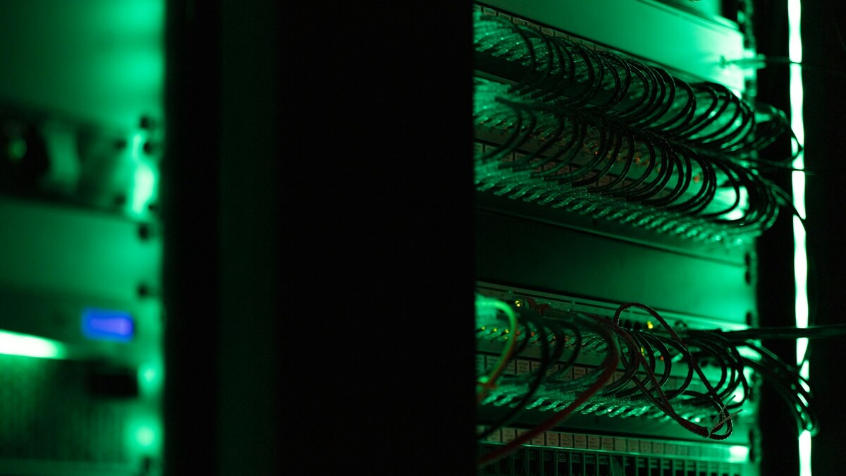 DeepSeek abre o DeepInfer: o que o motor de inferência entrega e exige Rack de equipamentos eletrônicos com luzes verdes em sala escura