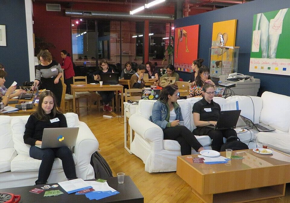Pessoas trabalhando com notebooks em um espaço de encontro de desenvolvedores