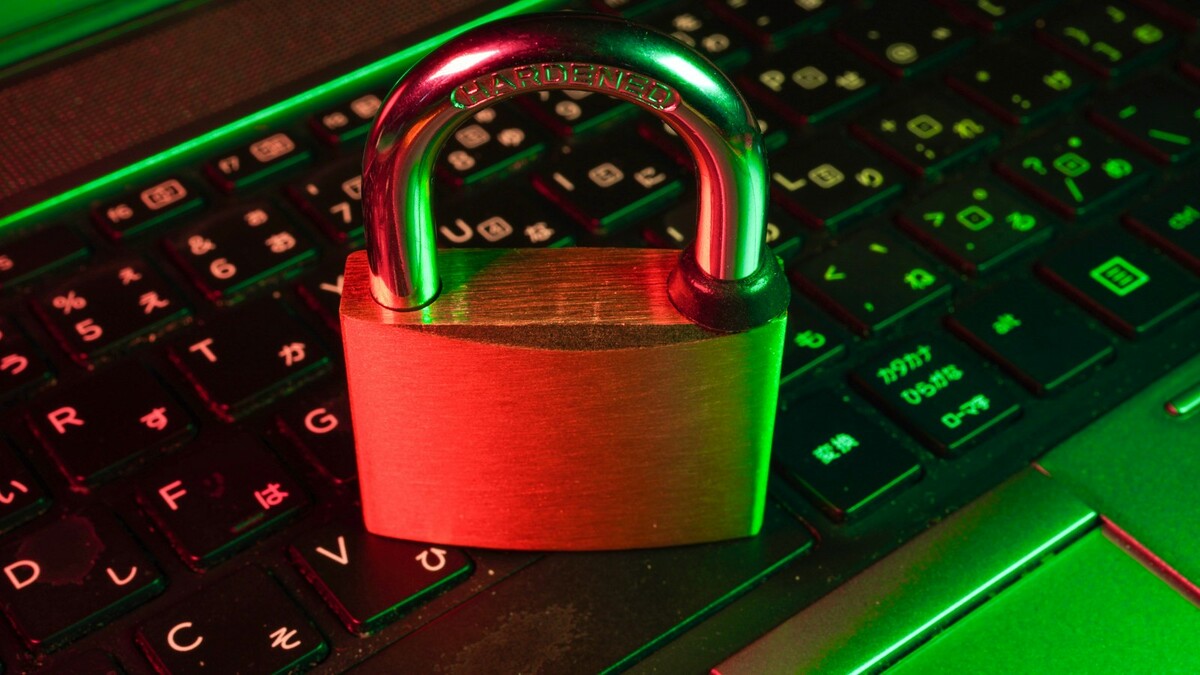 Cadeado vermelho sobre um teclado preto de computador