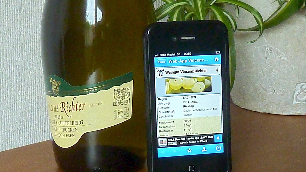 QR Code no café pode revelar a história do grão até a xícara? Celular exibindo ficha de produto ao lado de garrafa com QR Code no rótulo