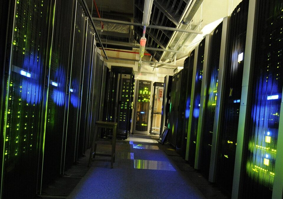 Corredor entre fileiras de servidores iluminados em um data center